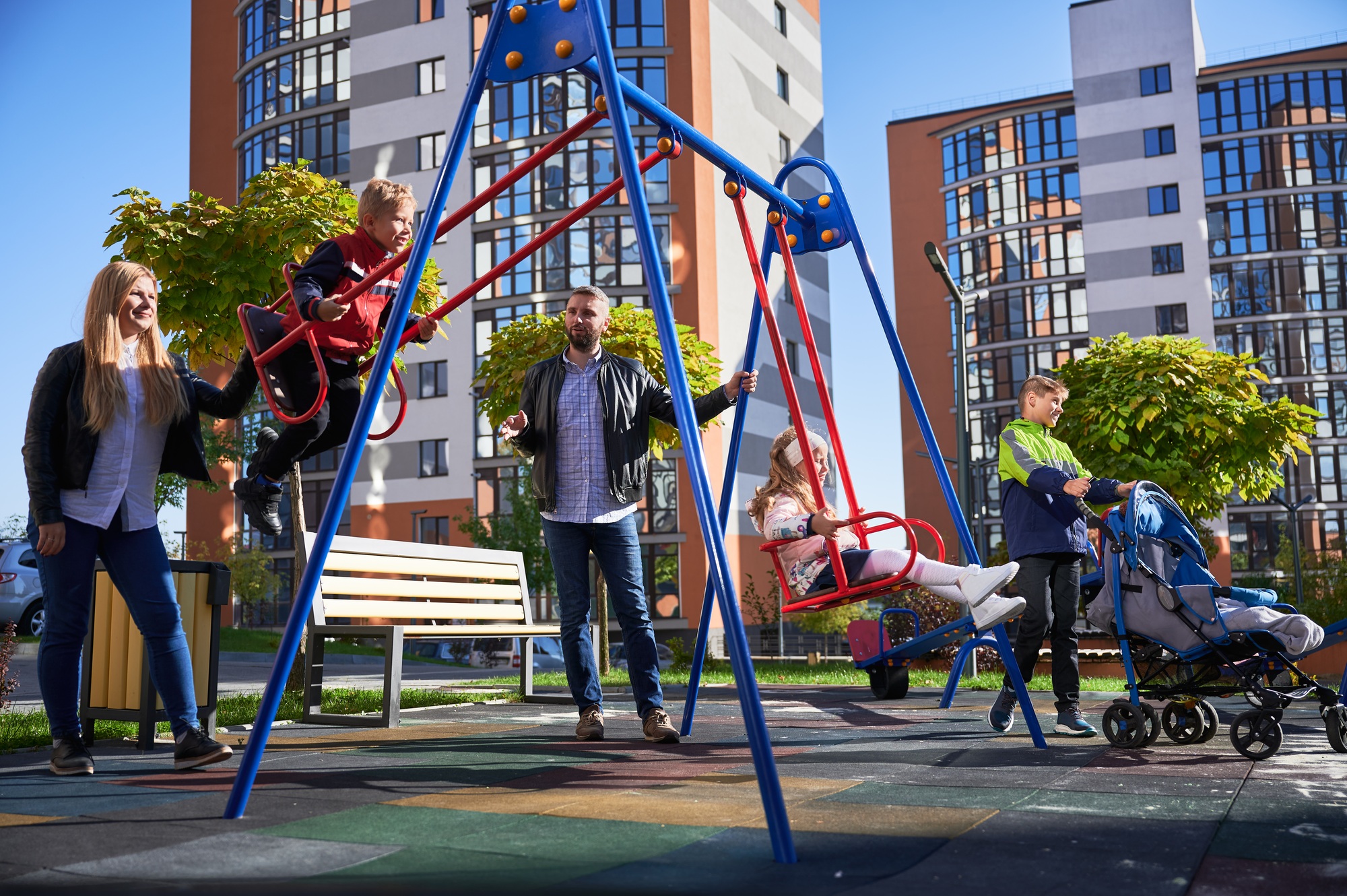 Large family with four kids by swing set.